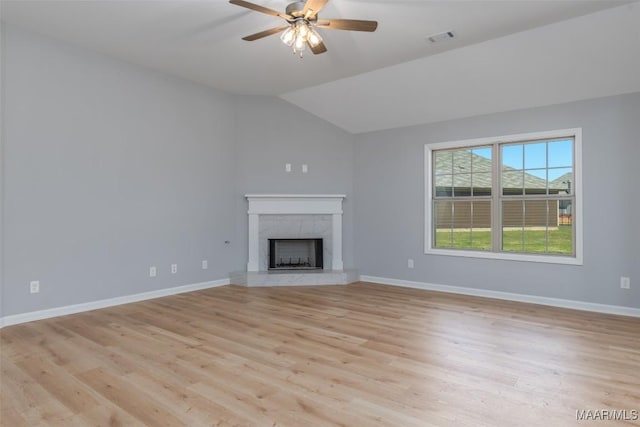 unfurnished living room with light wood-type flooring, visible vents, baseboards, and a premium fireplace