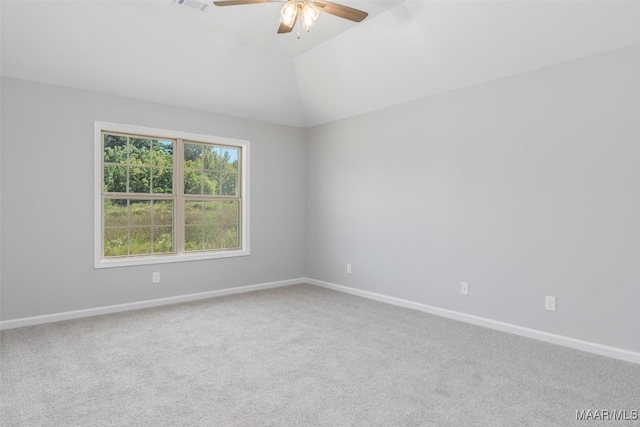 unfurnished room with carpet, visible vents, vaulted ceiling, and baseboards