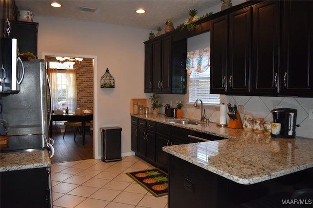 kitchen with light stone counters, sink, appliances with stainless steel finishes, and light hardwood / wood-style flooring