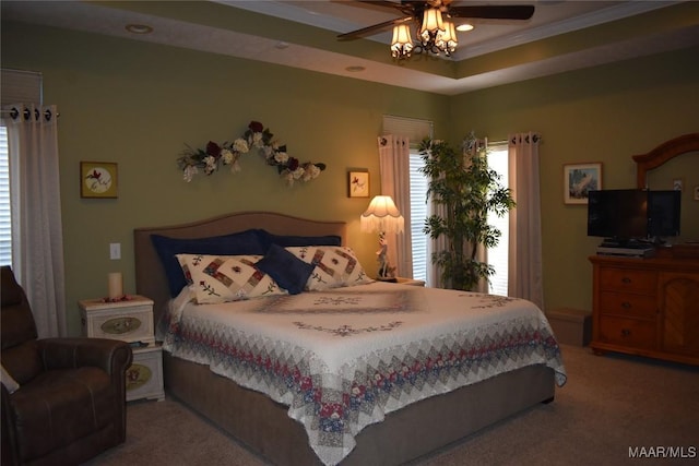 bedroom featuring carpet flooring, a tray ceiling, ceiling fan, and crown molding