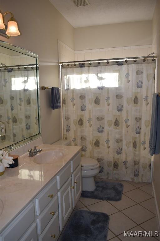 bathroom featuring tile patterned flooring, vanity, curtained shower, and toilet