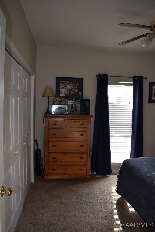 bedroom featuring ceiling fan, light colored carpet, and a closet