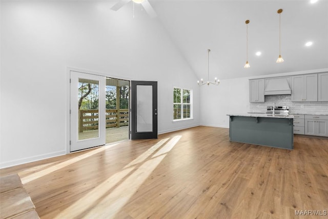 2065 Robinson Pond Rd, Prattville, AL 36067 - interior space with open floor plan, custom exhaust hood, gray cabinetry, a breakfast bar, and high vaulted ceiling