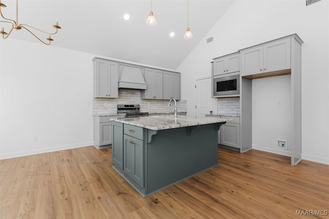2065 Robinson Pond Rd, Prattville, AL 36067 - kitchen with gray cabinetry, tasteful backsplash, appliances with stainless steel finishes, and premium range hood