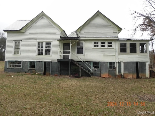 rear view of house featuring a yard