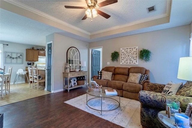 living room featuring crown molding, ceiling fan, light hardwood / wood-style floors, and a textured ceiling