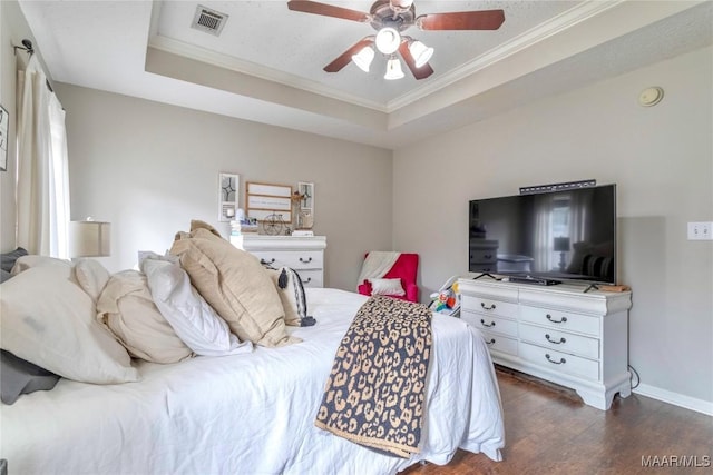 bedroom featuring a tray ceiling, ceiling fan, crown molding, and dark hardwood / wood-style floors