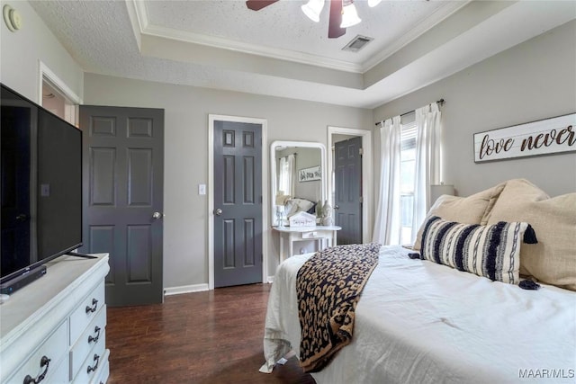 bedroom with a textured ceiling, a raised ceiling, ceiling fan, and dark hardwood / wood-style floors