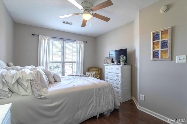 bedroom featuring a textured ceiling, ceiling fan, and dark wood-type flooring