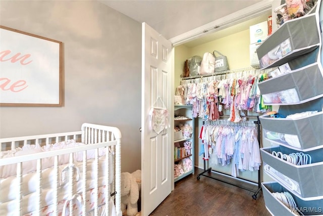 bedroom with a crib and hardwood / wood-style floors