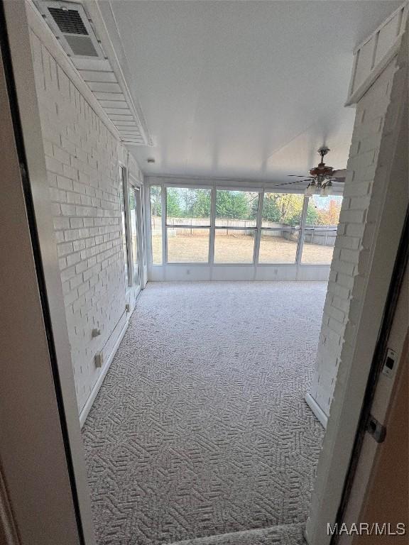 unfurnished sunroom featuring ceiling fan