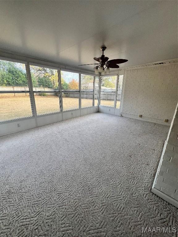 unfurnished sunroom featuring ceiling fan