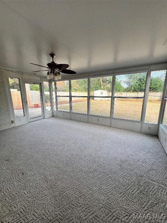 unfurnished sunroom featuring a wealth of natural light and ceiling fan