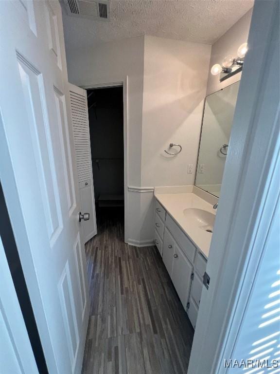 bathroom featuring vanity, hardwood / wood-style floors, and a textured ceiling