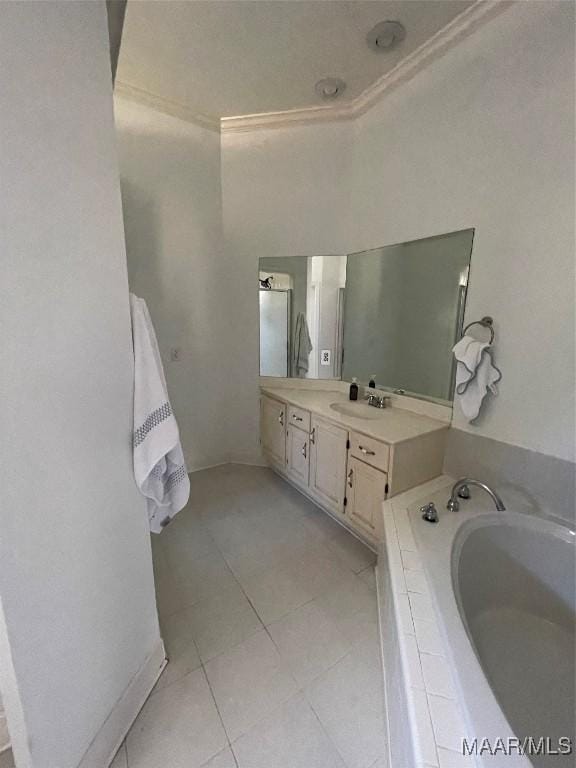 bathroom with tile patterned flooring, vanity, a relaxing tiled tub, and crown molding