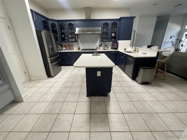 kitchen with sink, extractor fan, decorative backsplash, a kitchen island, and appliances with stainless steel finishes