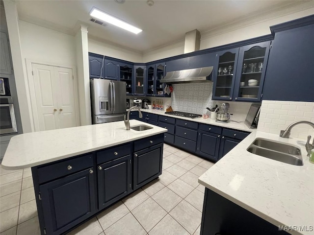 kitchen featuring extractor fan, sink, appliances with stainless steel finishes, and an island with sink