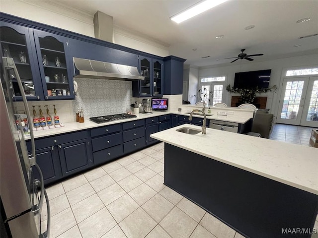 kitchen with french doors, sink, stainless steel appliances, and wall chimney range hood