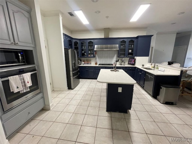 kitchen with a kitchen island with sink, black appliances, ventilation hood, sink, and light tile patterned flooring