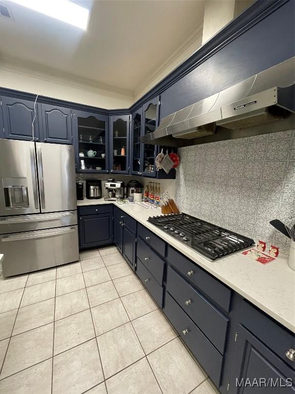 kitchen with ventilation hood, decorative backsplash, stainless steel fridge, light tile patterned floors, and gas cooktop