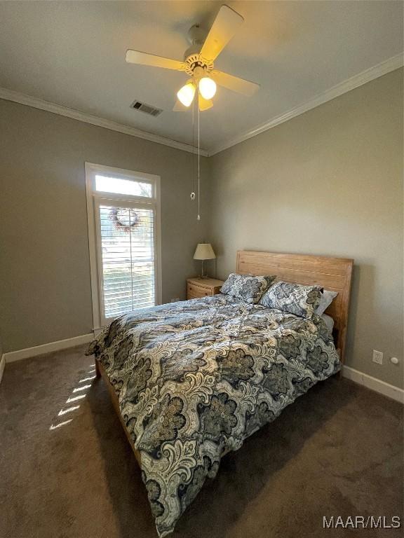 bedroom with ceiling fan, ornamental molding, and dark colored carpet