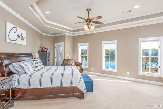 carpeted bedroom with a raised ceiling, multiple windows, crown molding, and ceiling fan