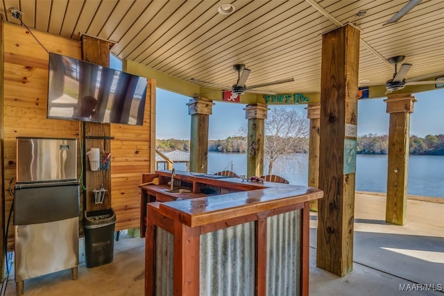 view of patio featuring ceiling fan and a bar