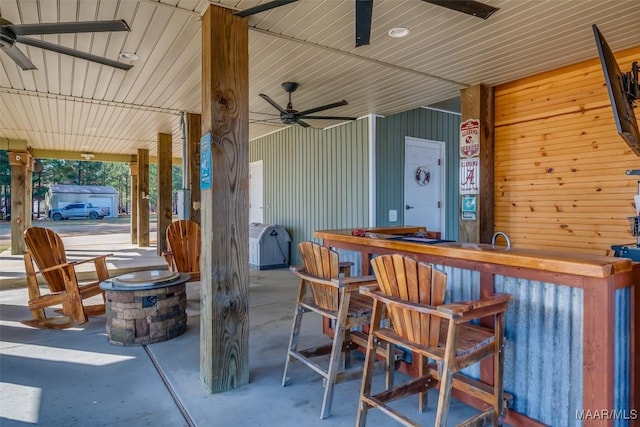 view of patio with ceiling fan and an outdoor bar