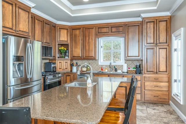 kitchen with a kitchen bar, stainless steel appliances, light stone counters, and sink