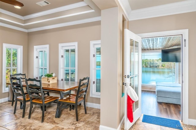 dining room featuring light wood-type flooring, ornamental molding, and a tray ceiling