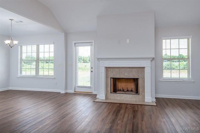 unfurnished living room featuring dark hardwood / wood-style floors, a healthy amount of sunlight, and a tile fireplace