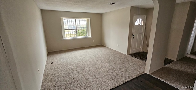 entryway with carpet floors and a textured ceiling