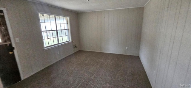 unfurnished room featuring dark carpet