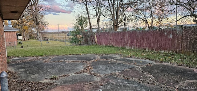 yard at dusk featuring a patio