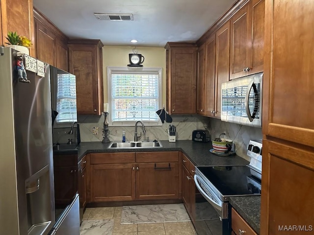 kitchen featuring appliances with stainless steel finishes, backsplash, and sink