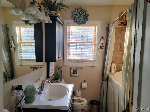 full bathroom featuring vanity, shower / tub combo, washing machine and dryer, and toilet