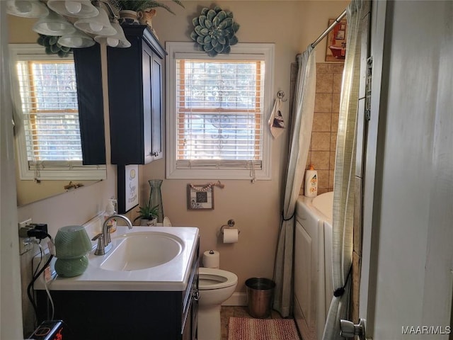 full bathroom featuring shower / tub combo with curtain, vanity, washer and dryer, and toilet