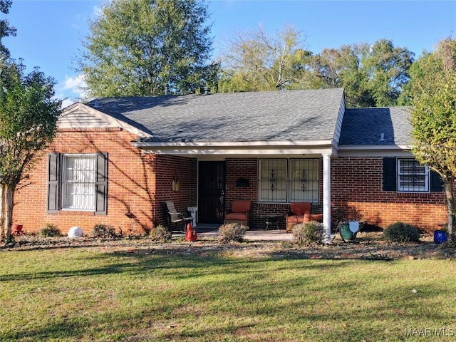 ranch-style home featuring covered porch and a front yard