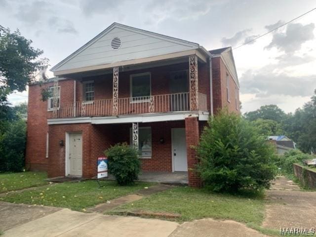 view of front of property with a balcony and a front yard