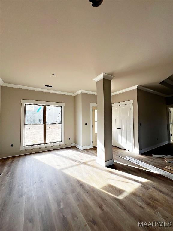 unfurnished living room with crown molding and hardwood / wood-style flooring