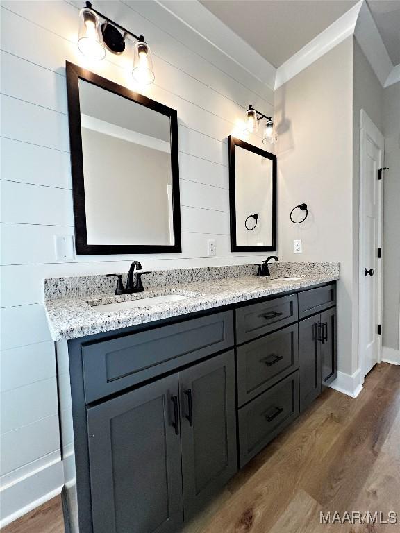 bathroom featuring hardwood / wood-style flooring, ornamental molding, and vanity