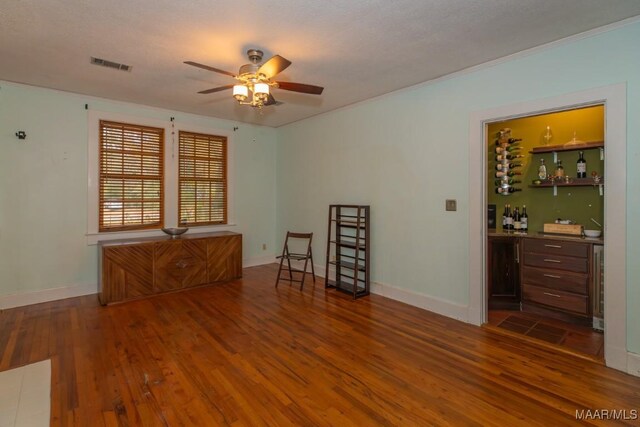 1220 Westmoreland Ave, Montgomery, AL 36106 - empty room featuring bar, wood finished floors, ceiling fan, beverage cooler, and ornamental molding