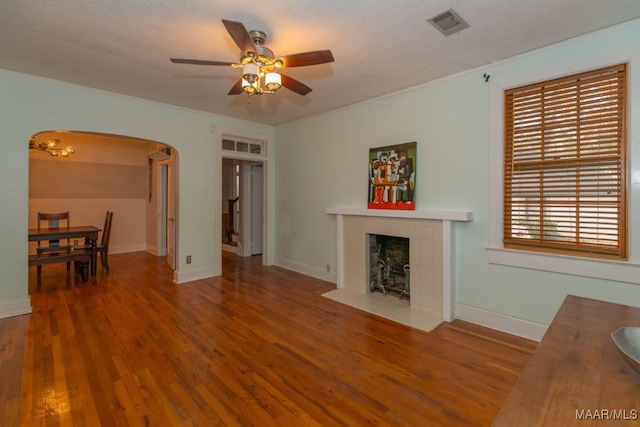 1220 Westmoreland Ave, Montgomery, AL 36106 - living area with arched walkways, a ceiling fan, wood finished floors, and a fireplace