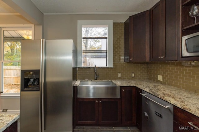 kitchen with sink, light stone counters, decorative backsplash, appliances with stainless steel finishes, and ornamental molding