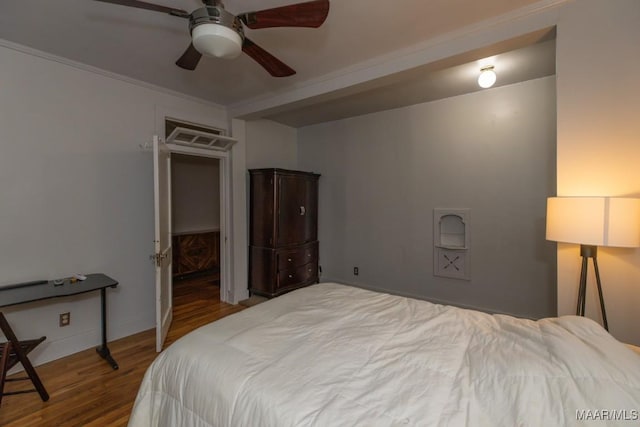 bedroom featuring hardwood / wood-style flooring, ceiling fan, and crown molding