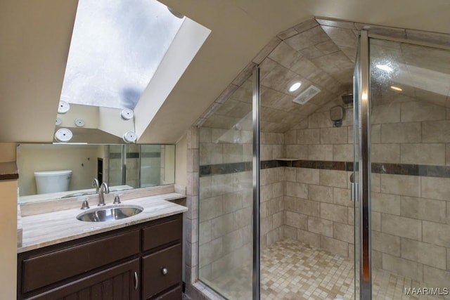 bathroom with vanity, toilet, and a shower with shower door