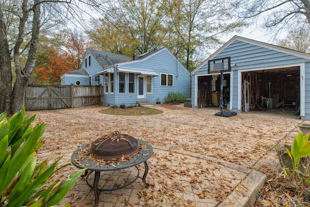 rear view of property with an outdoor fire pit and a sunroom