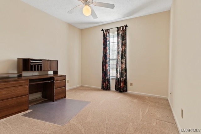 carpeted office space featuring ceiling fan