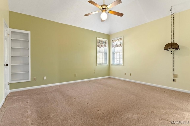 carpeted empty room with ceiling fan, built in features, and lofted ceiling