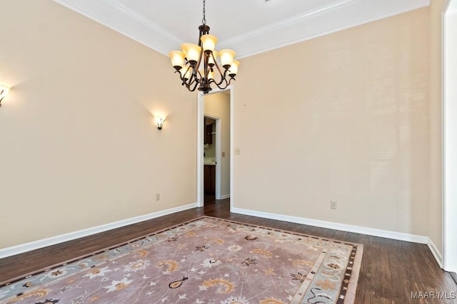 unfurnished room with ornamental molding, dark wood-type flooring, and an inviting chandelier